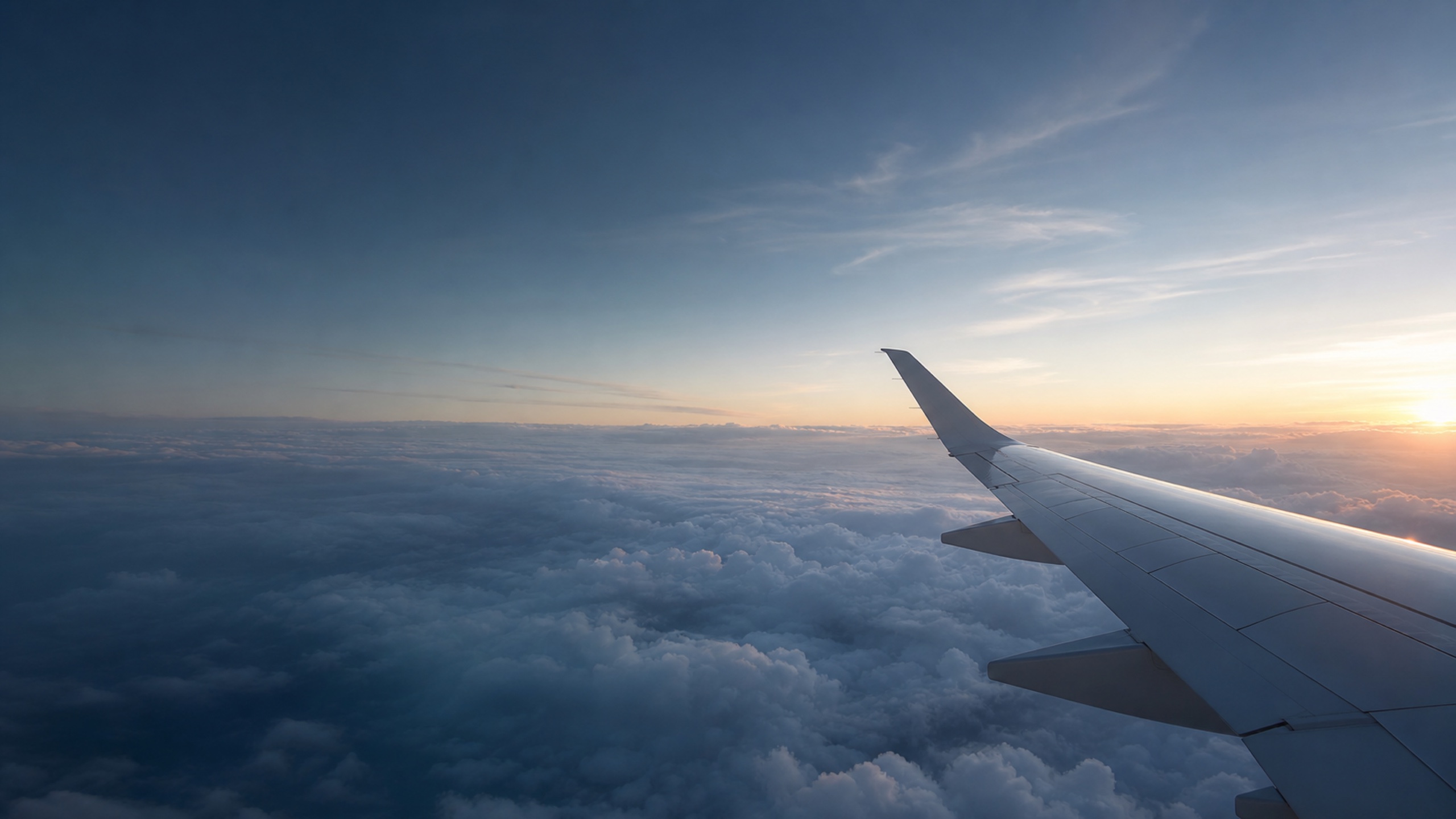 Airplane wing above a calm layer of clouds.